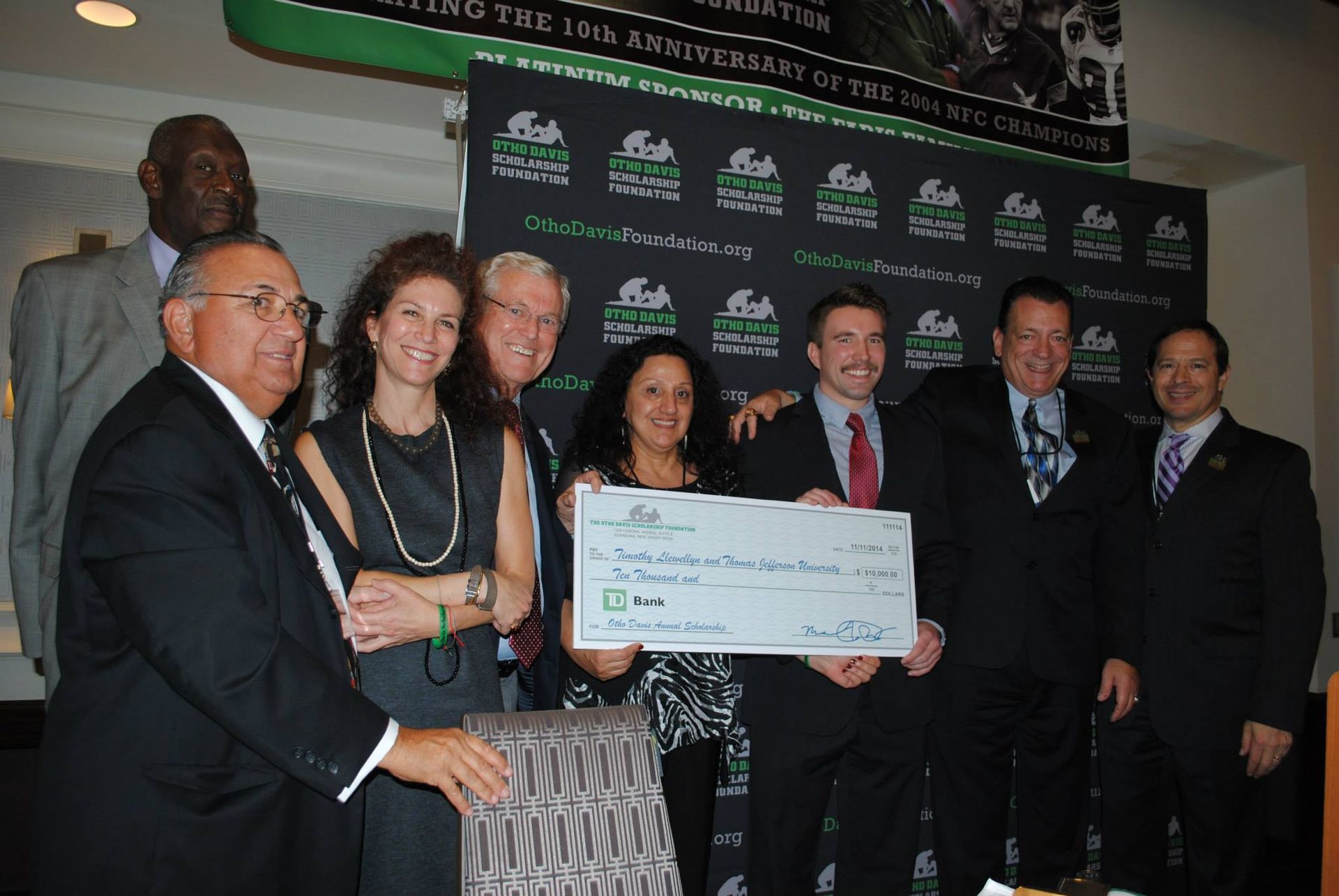 A group of people posing for a picture while holding a large check