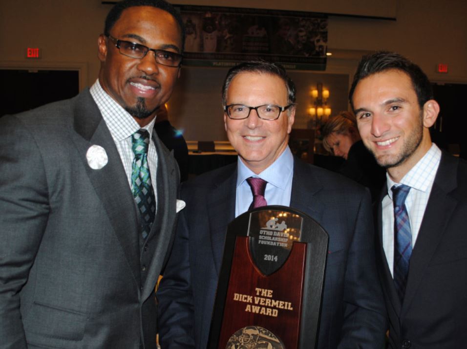 Three men holding a plaque that says the performer award