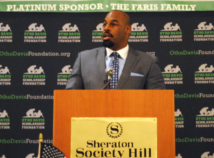 A man stands behind a podium that says sheraton society hill