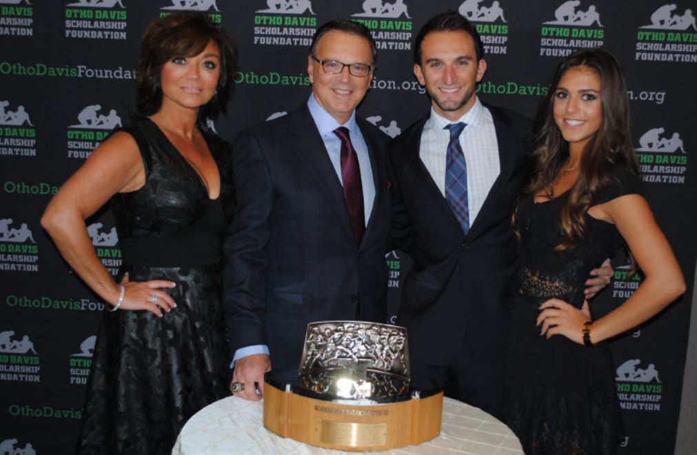 A group of people standing around a table with a trophy on it
