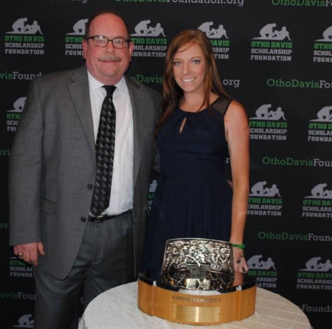 A man and a woman pose for a photo in front of a ohio davis scholarship foundation backdrop
