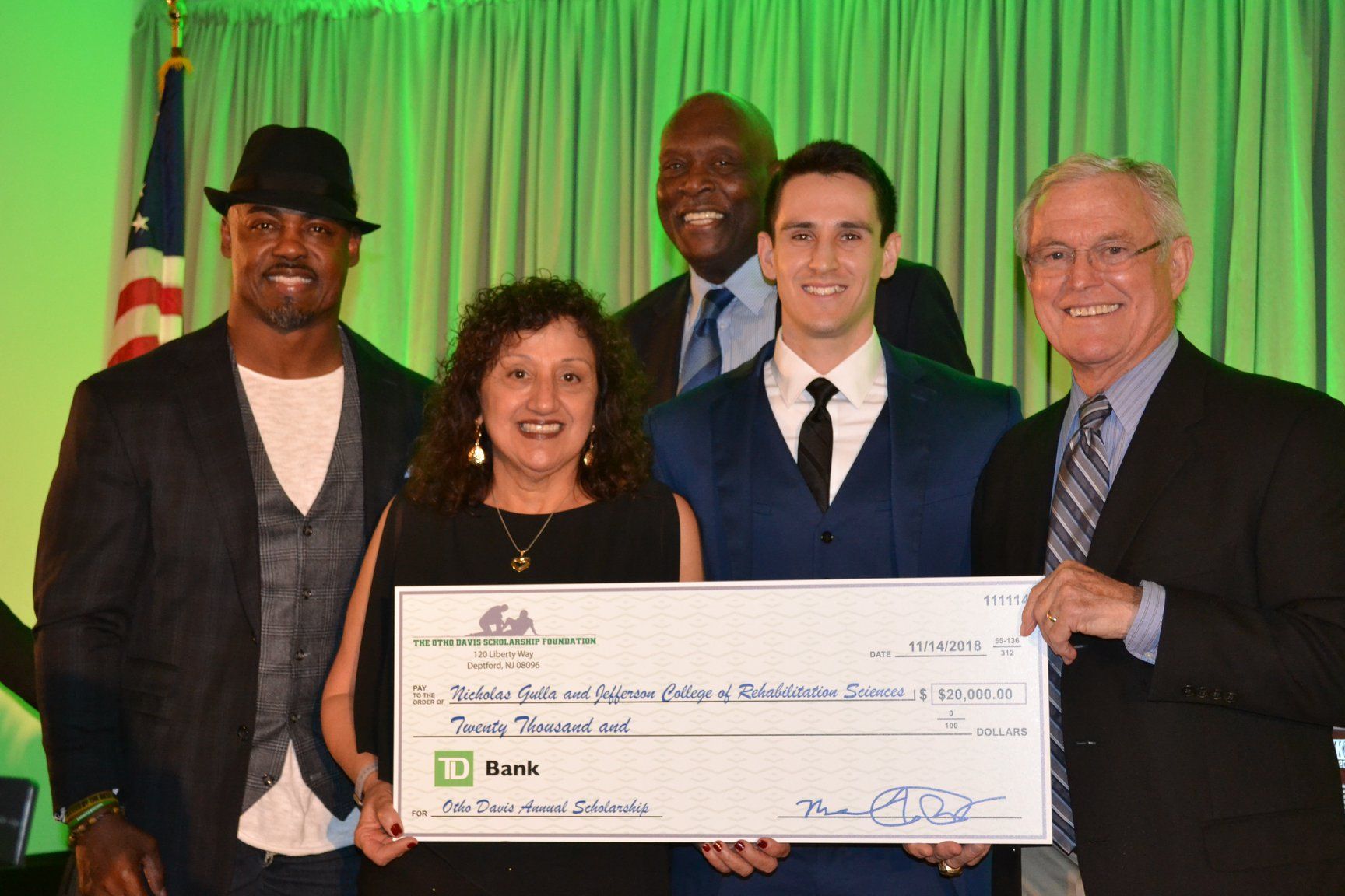 A group of people standing next to each other holding a large check.