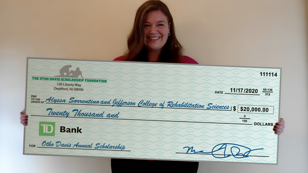 A woman is holding a large check from td bank