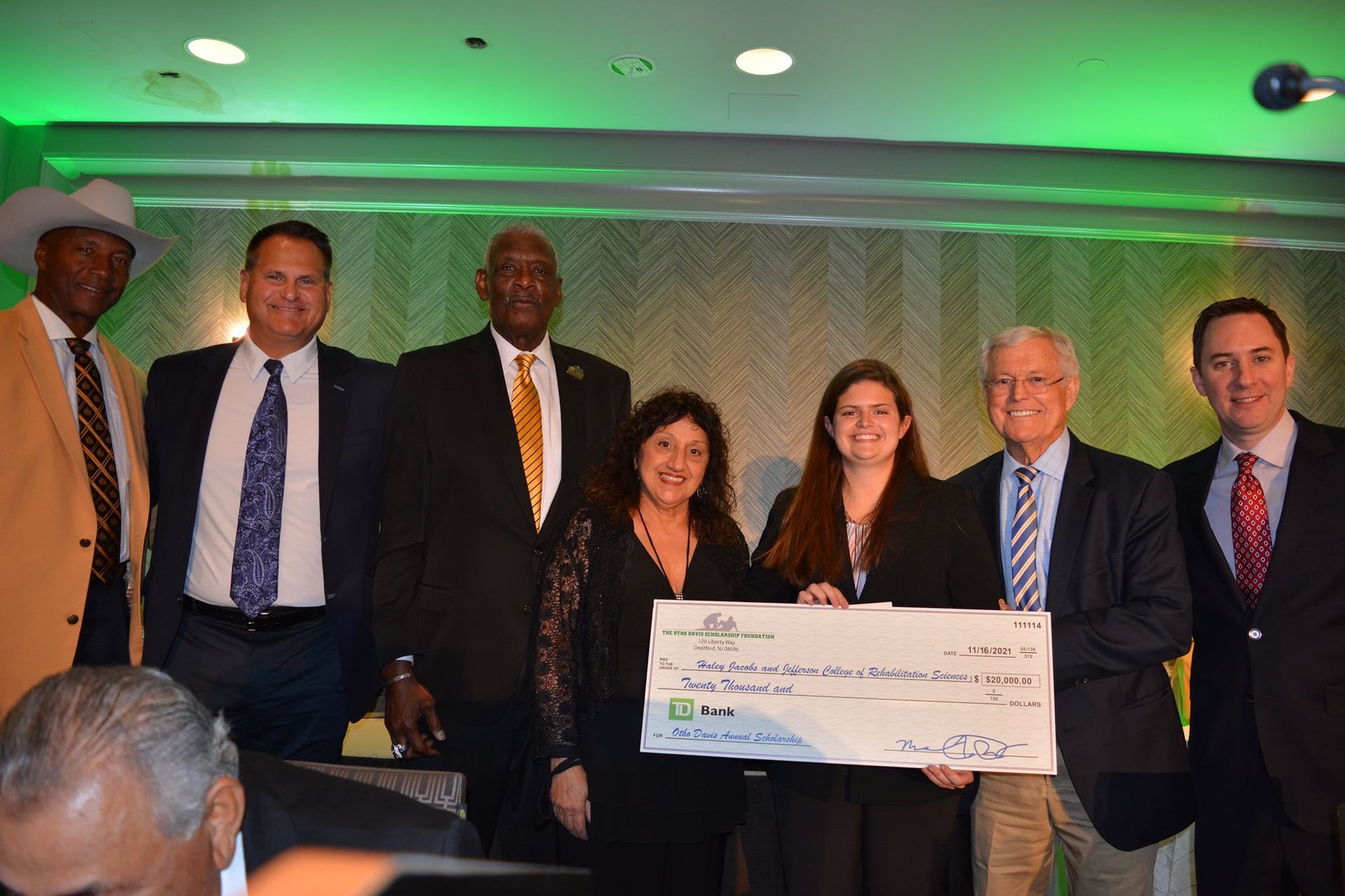 A group of people standing next to each other holding a large check
