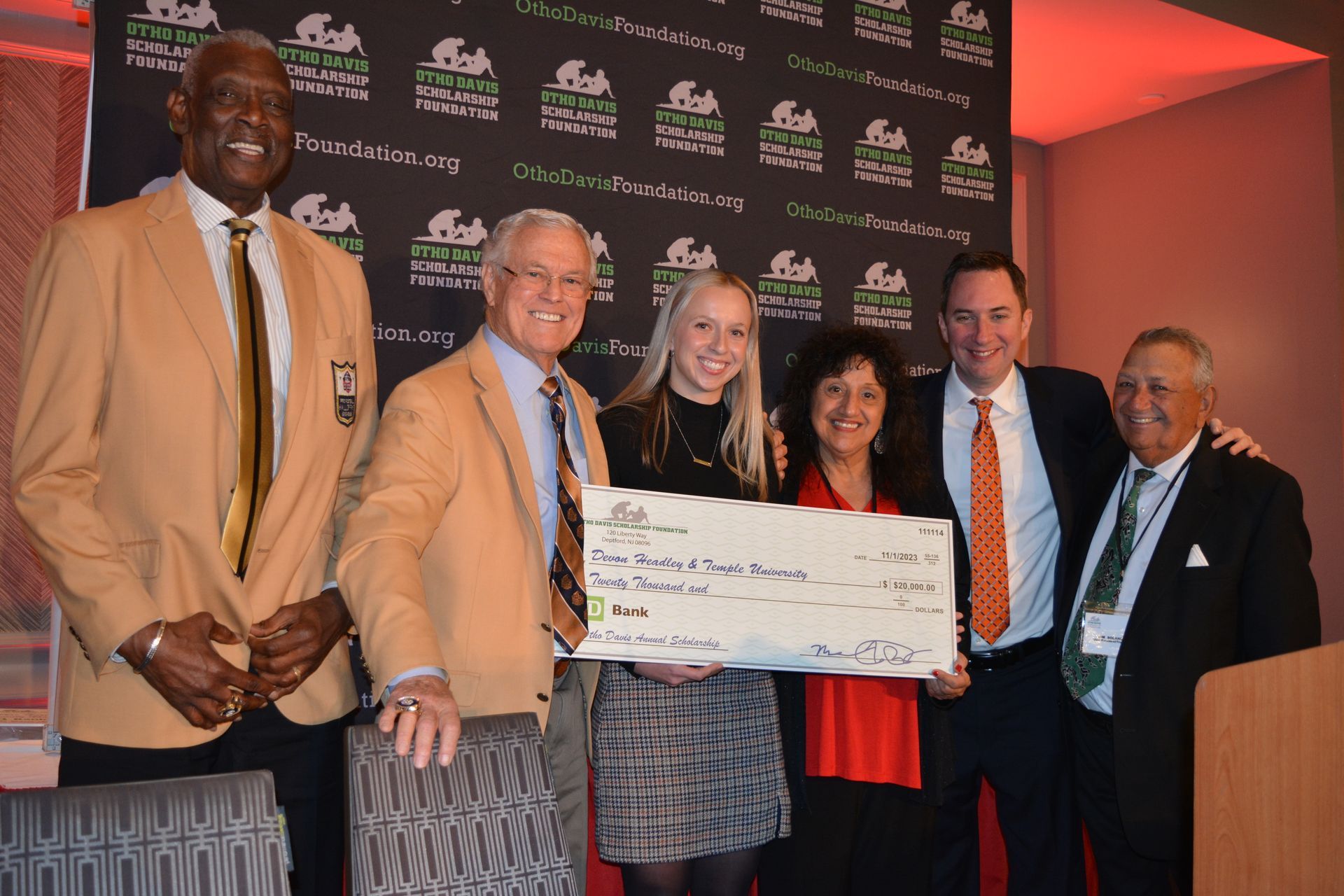 A group of people posing for a picture holding a large check