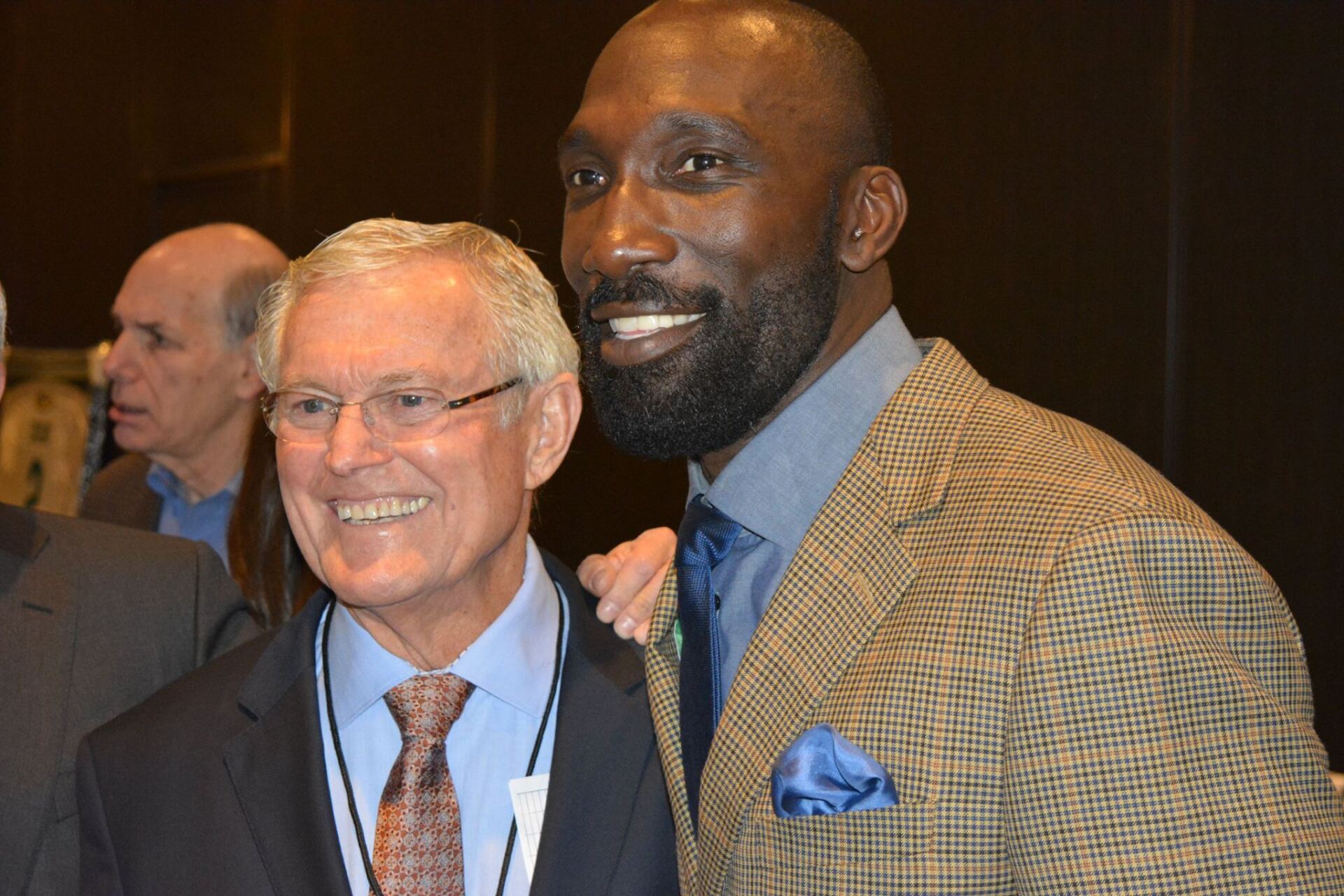 Two men in suits and ties are posing for a picture.