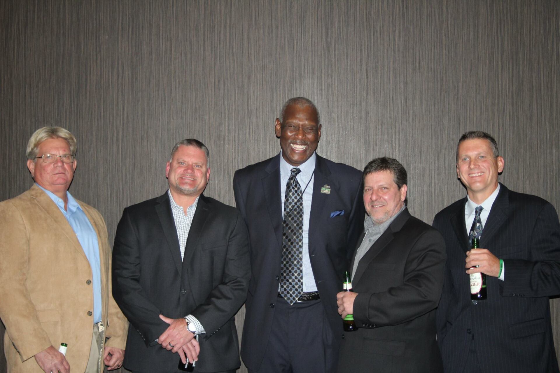A group of men in suits and ties are posing for a picture.