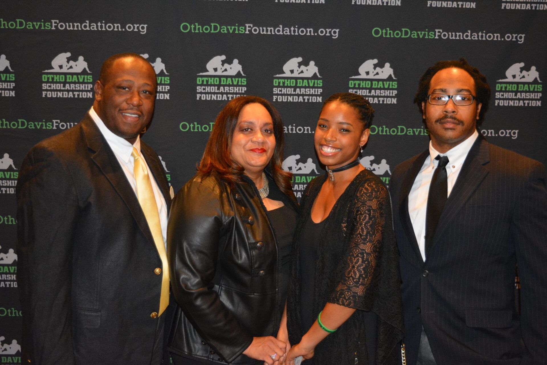 A group of people are posing for a picture in front of a wall that says foundation.org