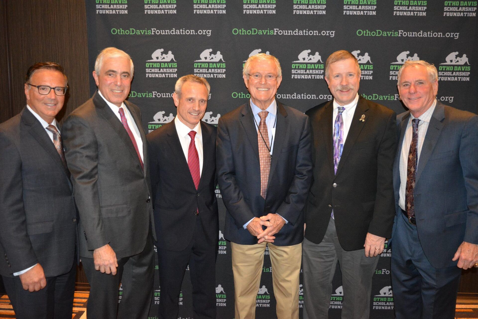 A group of men in suits and ties pose for a picture
