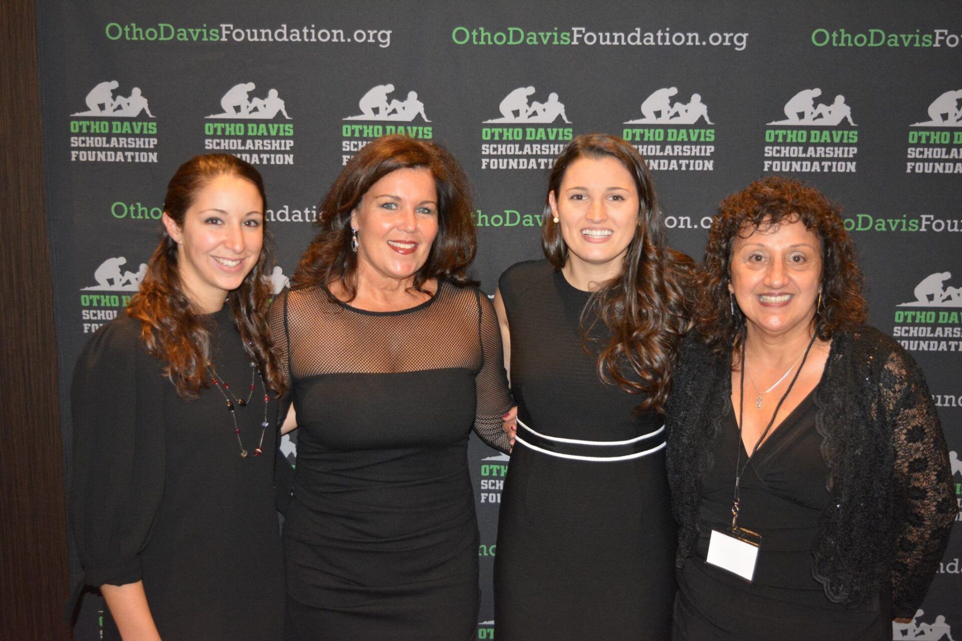 Four women are posing for a picture in front of a wall that says ohio davis foundation