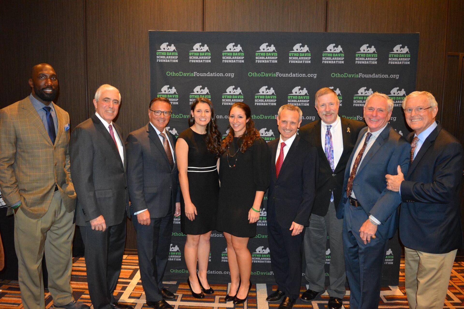 A group of people in suits and ties are posing for a picture.