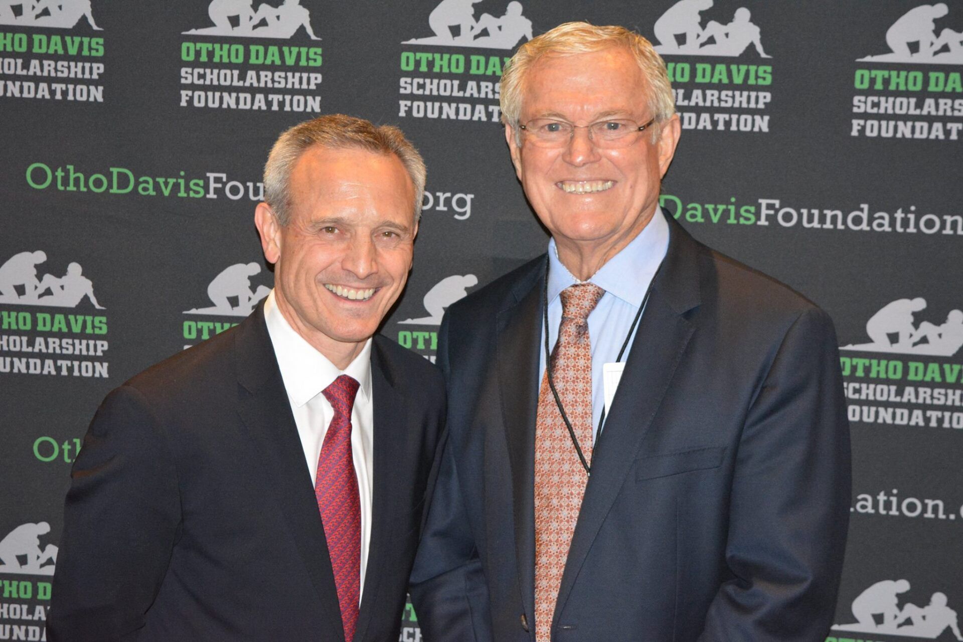 Two men are posing for a picture in front of a wall that says ohio davis scholarship foundation