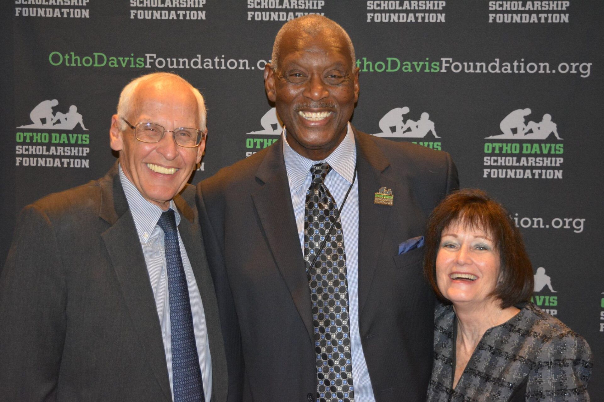 Three people are posing for a picture in front of a sign that says ohio davis scholarship foundation