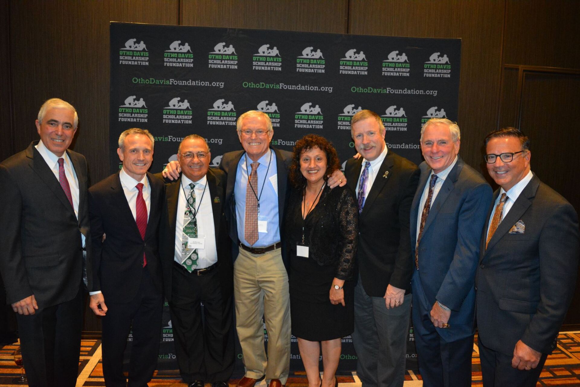 A group of people in suits and ties are posing for a picture.