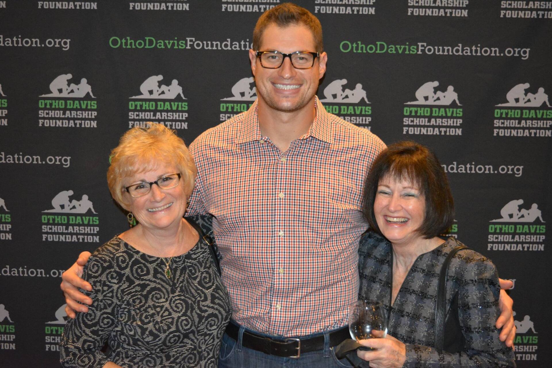 A man and two women are posing for a picture in front of a wall that says ohio davis foundation