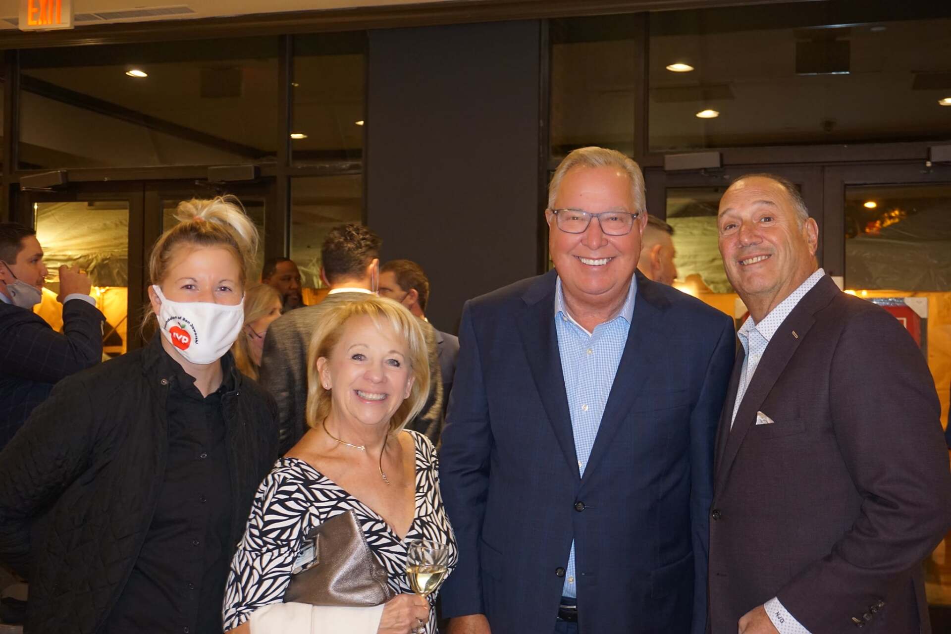 A group of people wearing face masks are posing for a picture.