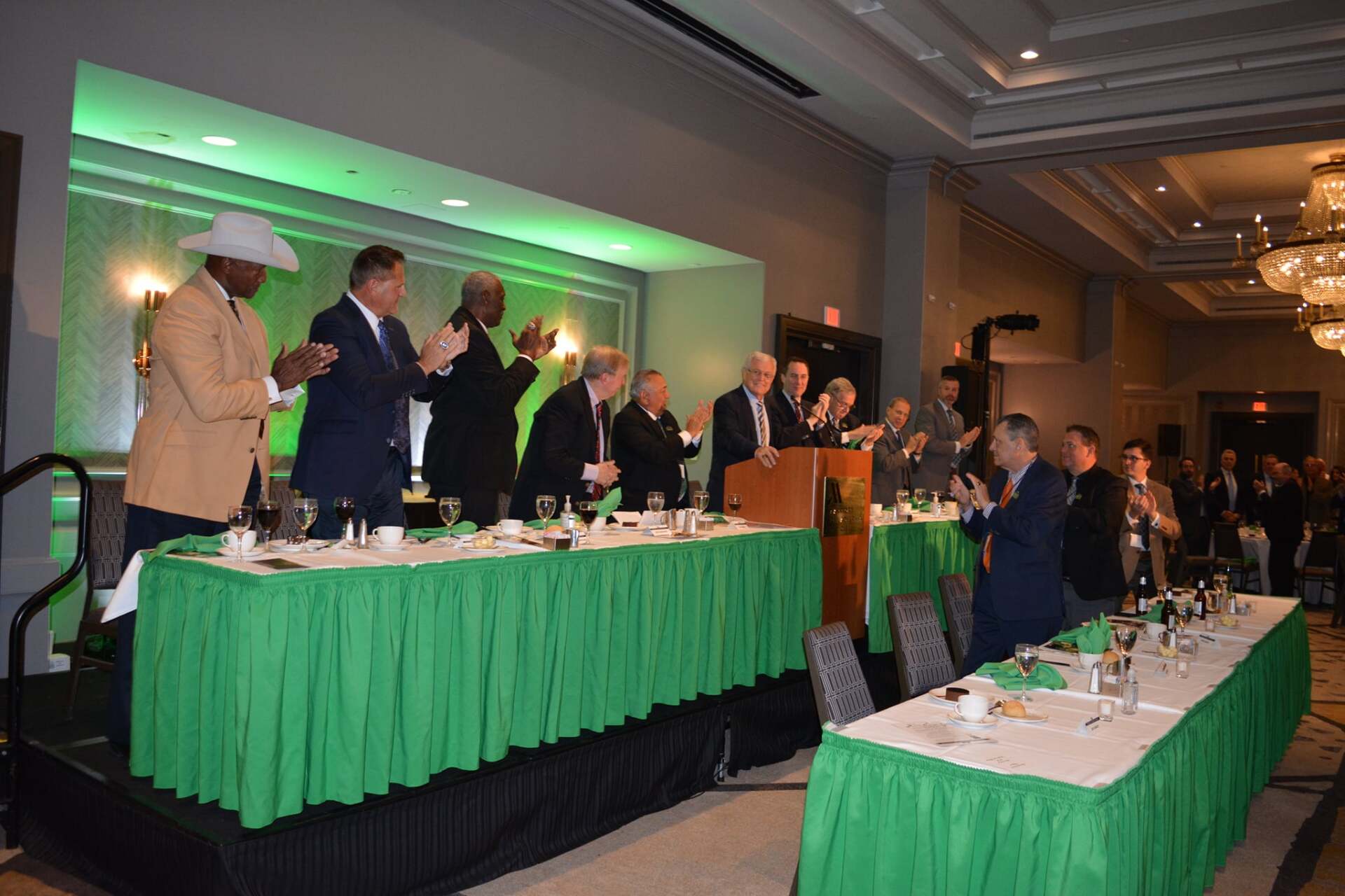 A group of men are standing around a long table in a room.