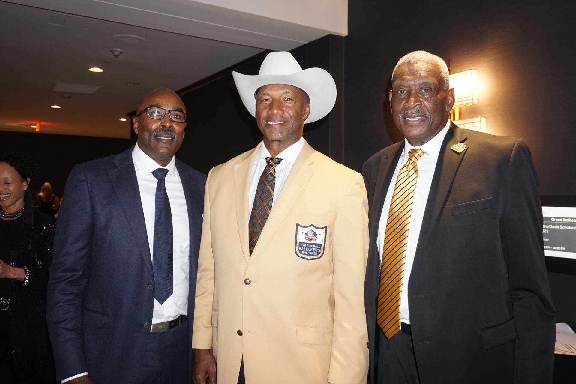Three men in suits and ties are posing for a picture