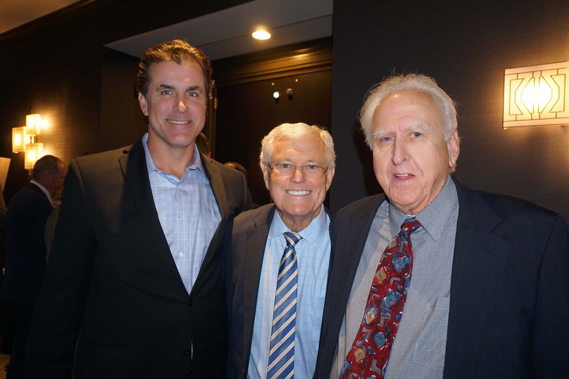 Three men in suits and ties are posing for a picture.