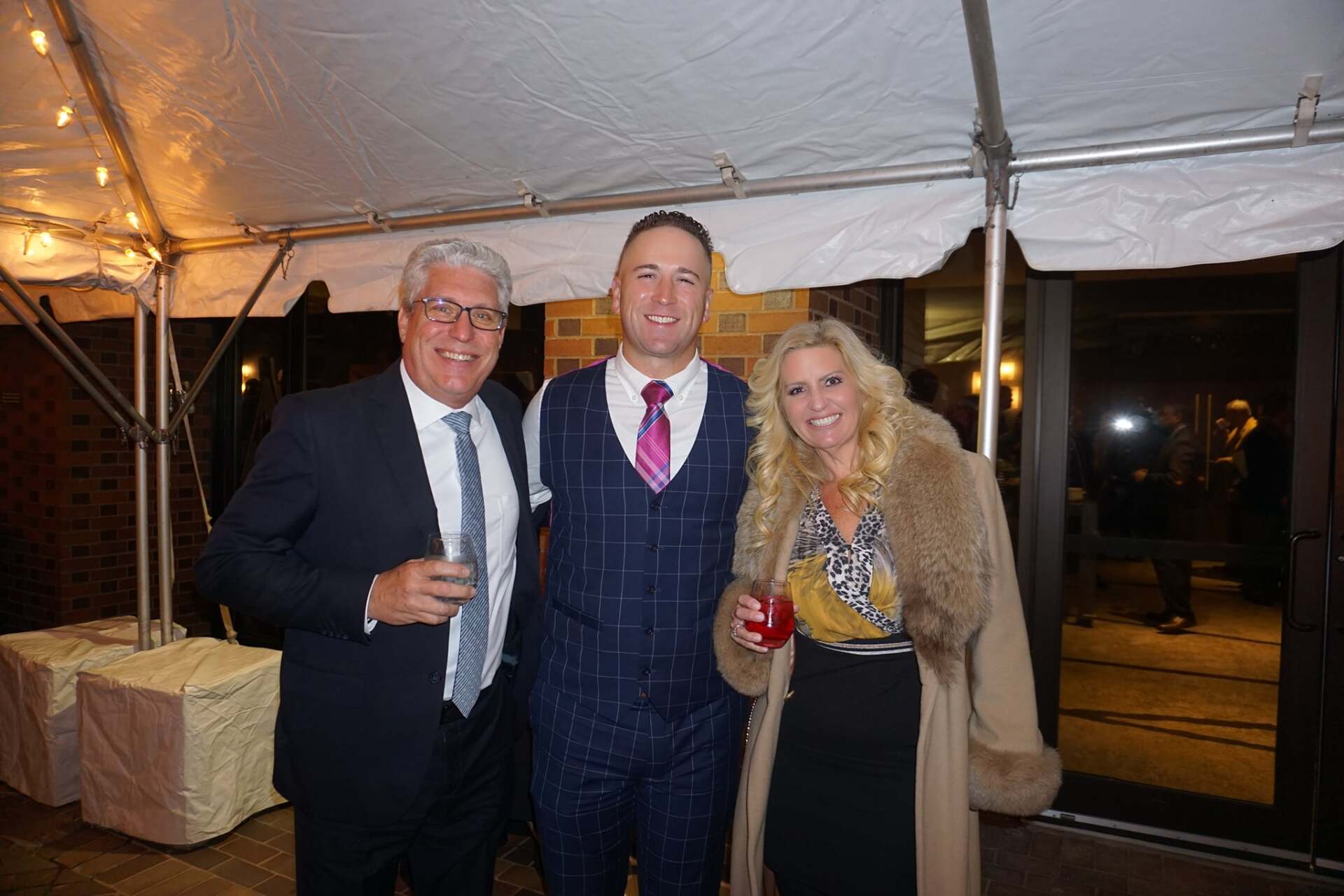 A group of people are posing for a picture under a tent.