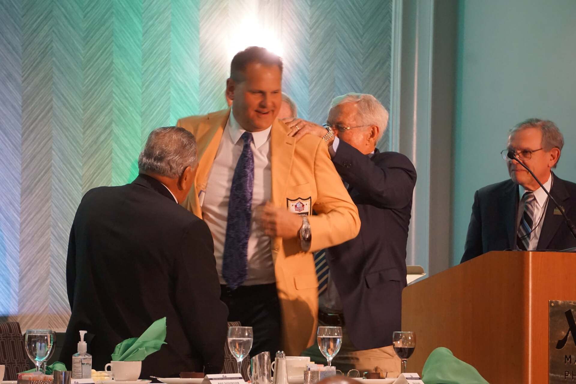 A man in a suit and tie is hugging another man