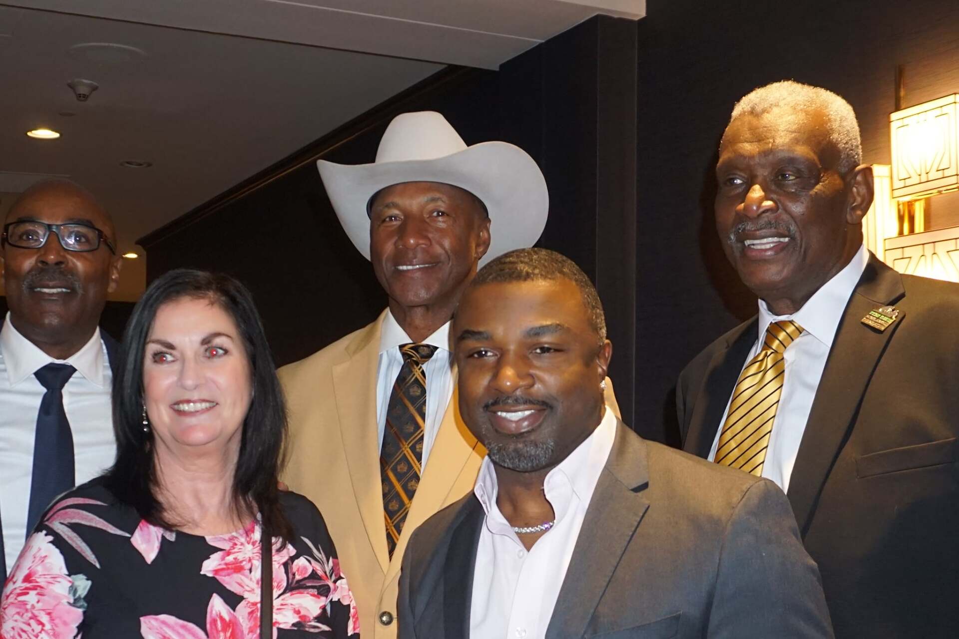A group of people posing for a picture with one wearing a cowboy hat