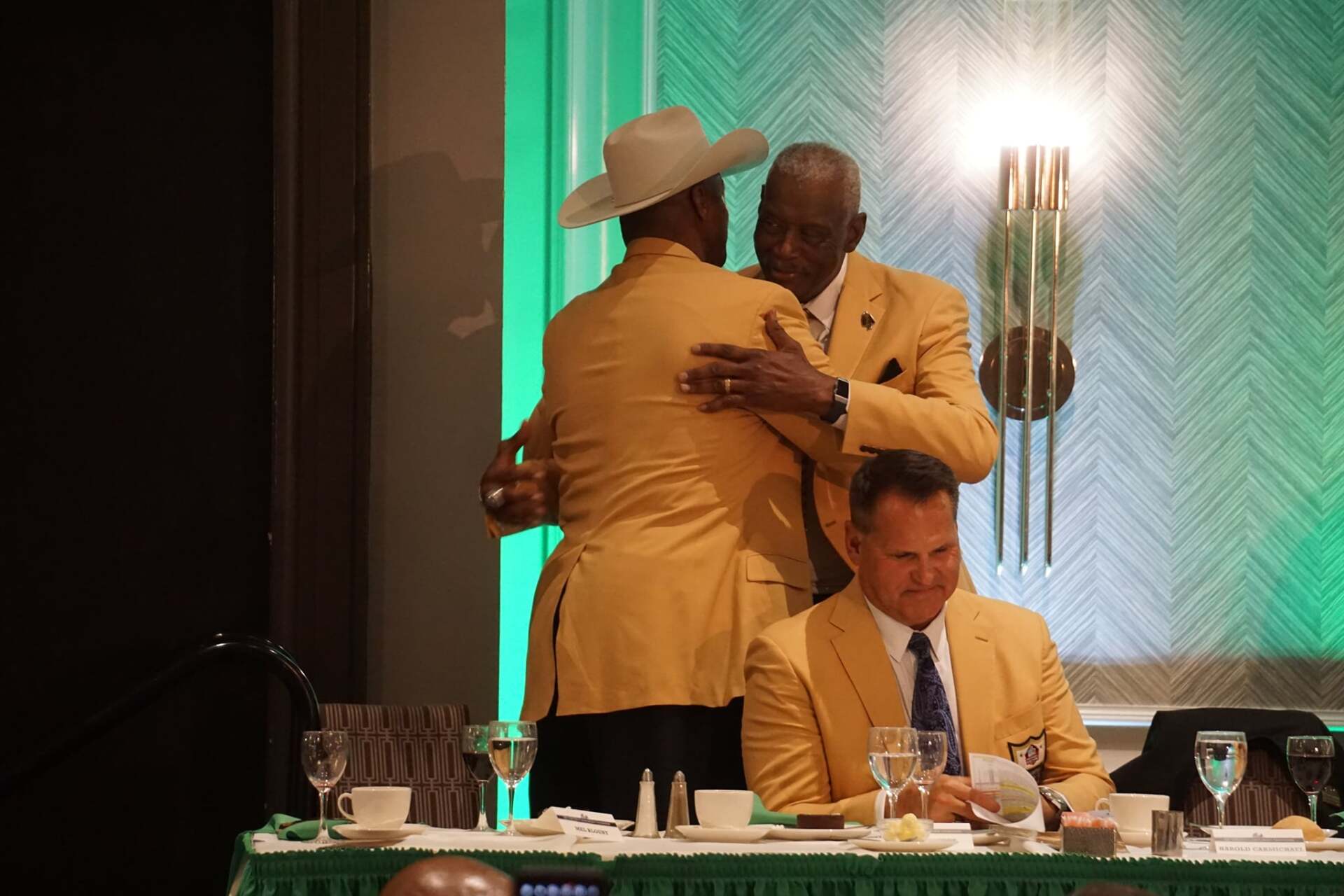 A group of men are hugging each other at a table.