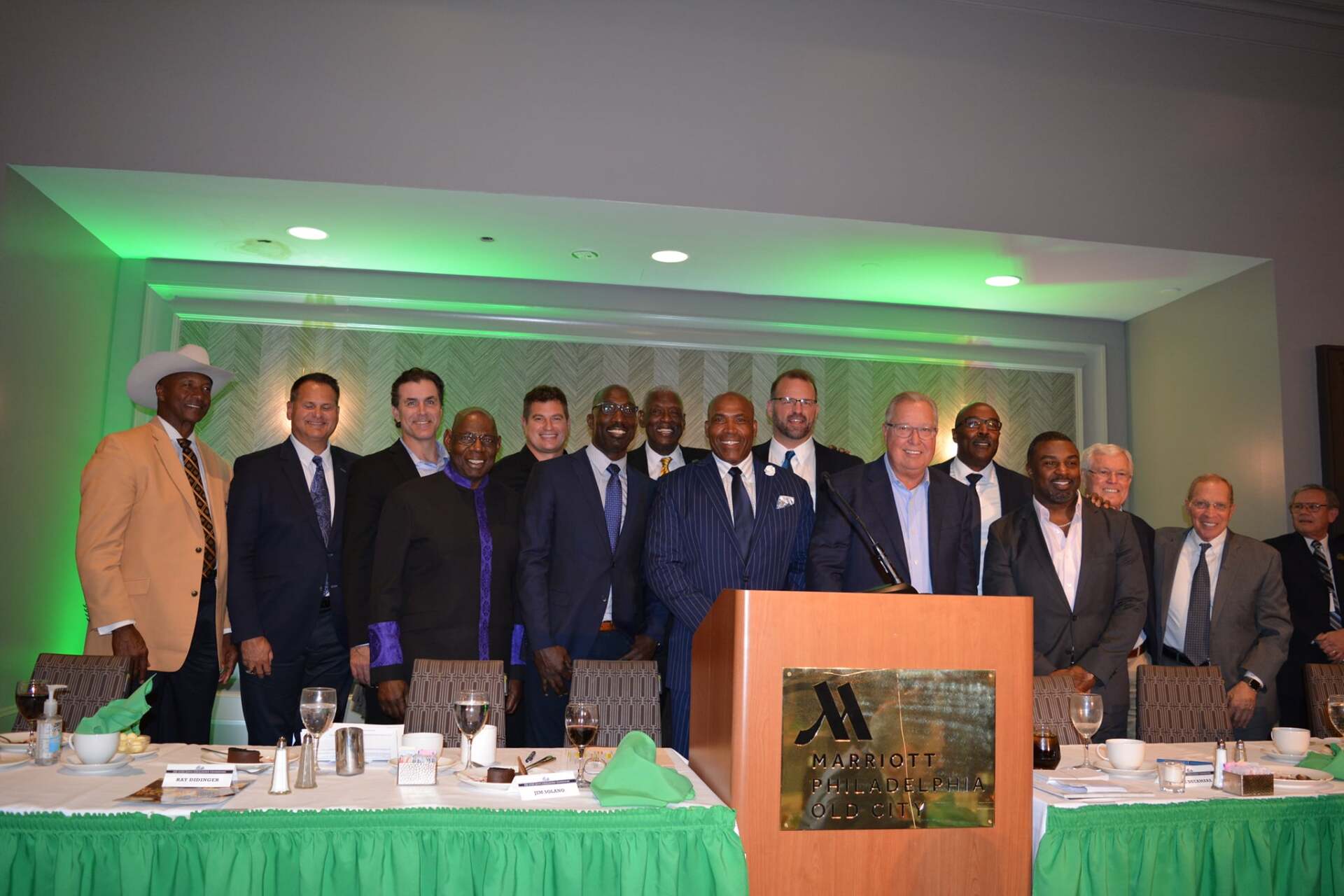 A group of men are posing for a picture in front of a podium.