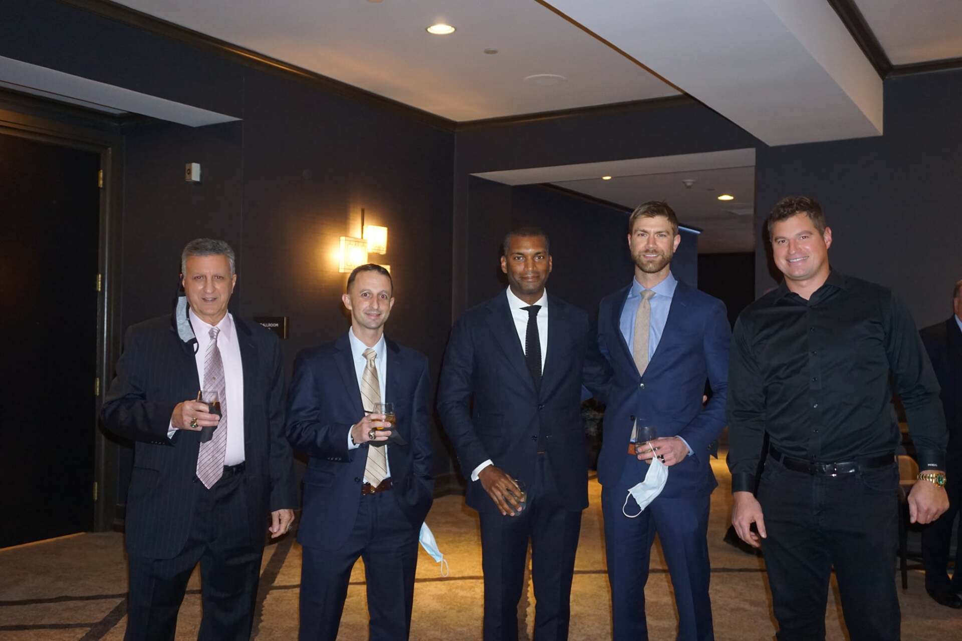 A group of men in suits and ties are posing for a picture.