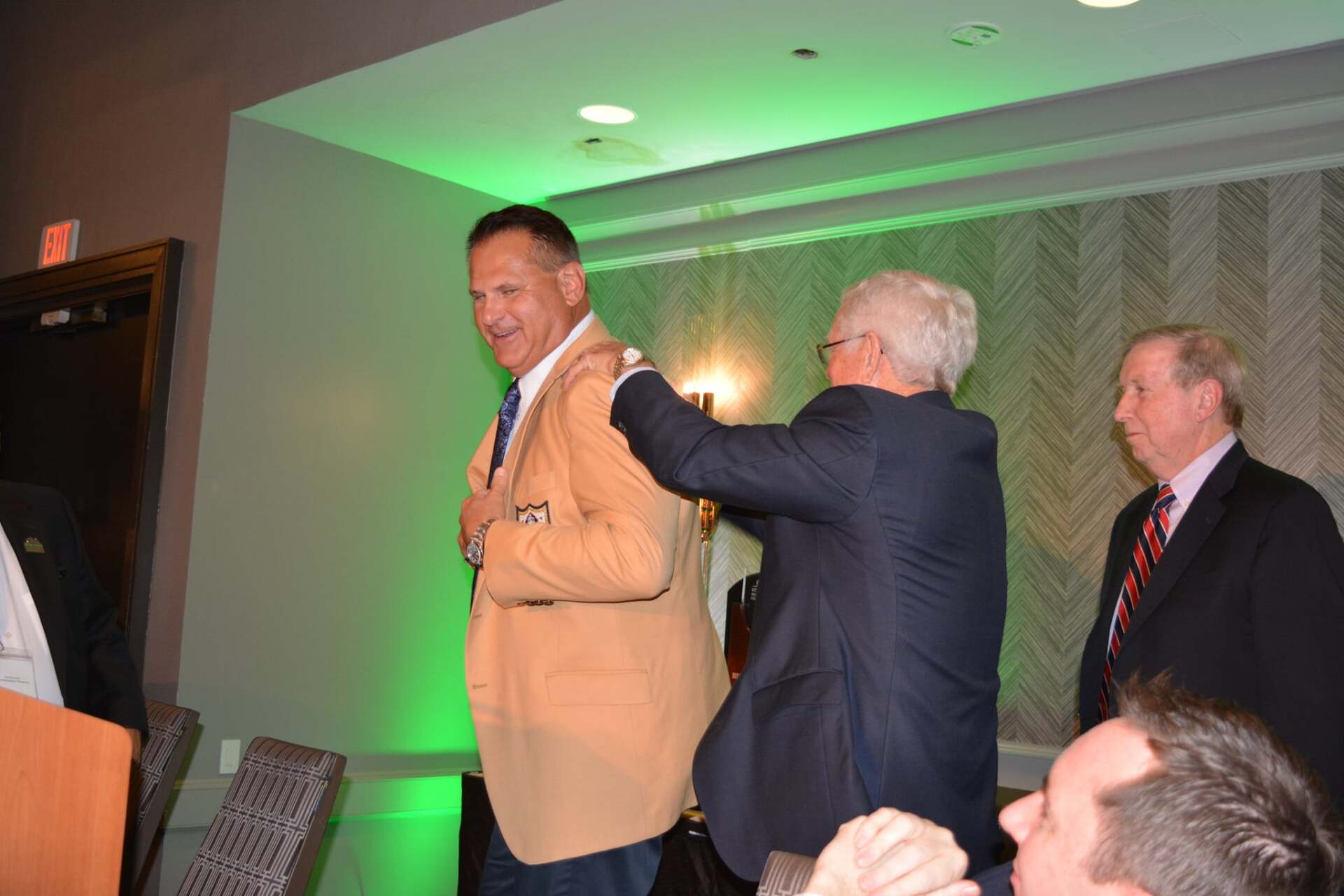 A group of men in suits are standing in a room.