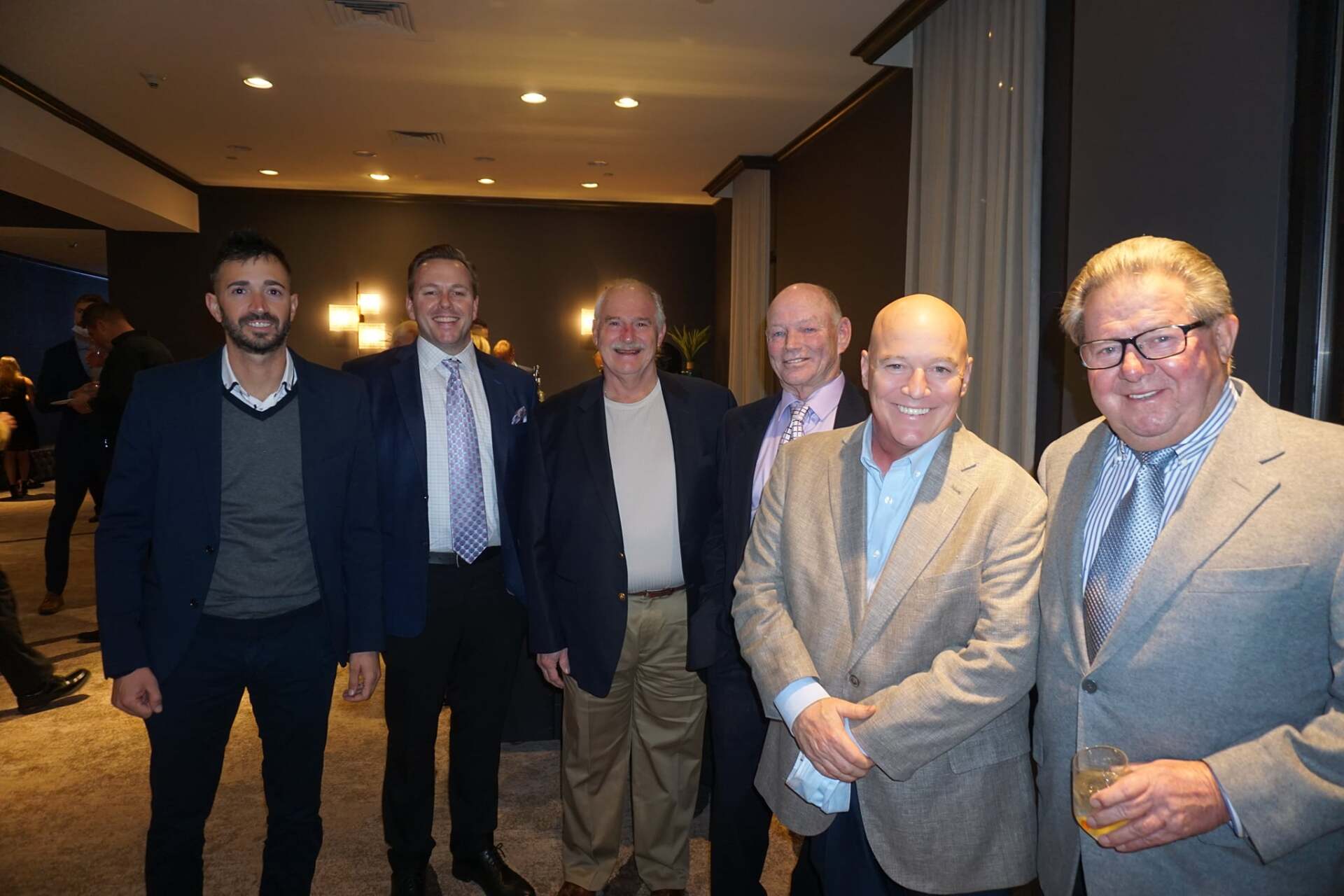 A group of men in suits and ties are posing for a picture.