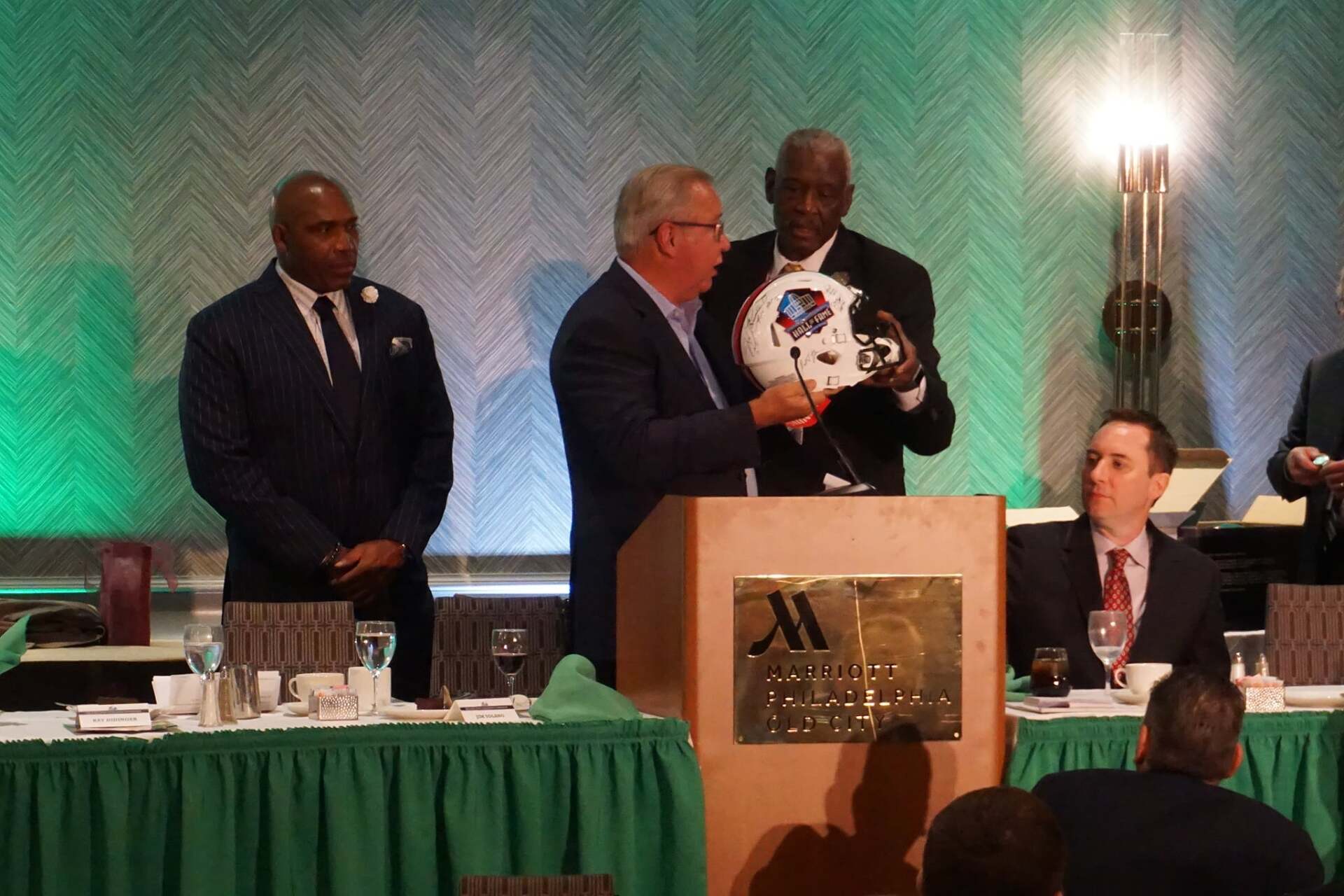 A man is holding a helmet in front of a podium that says marriott