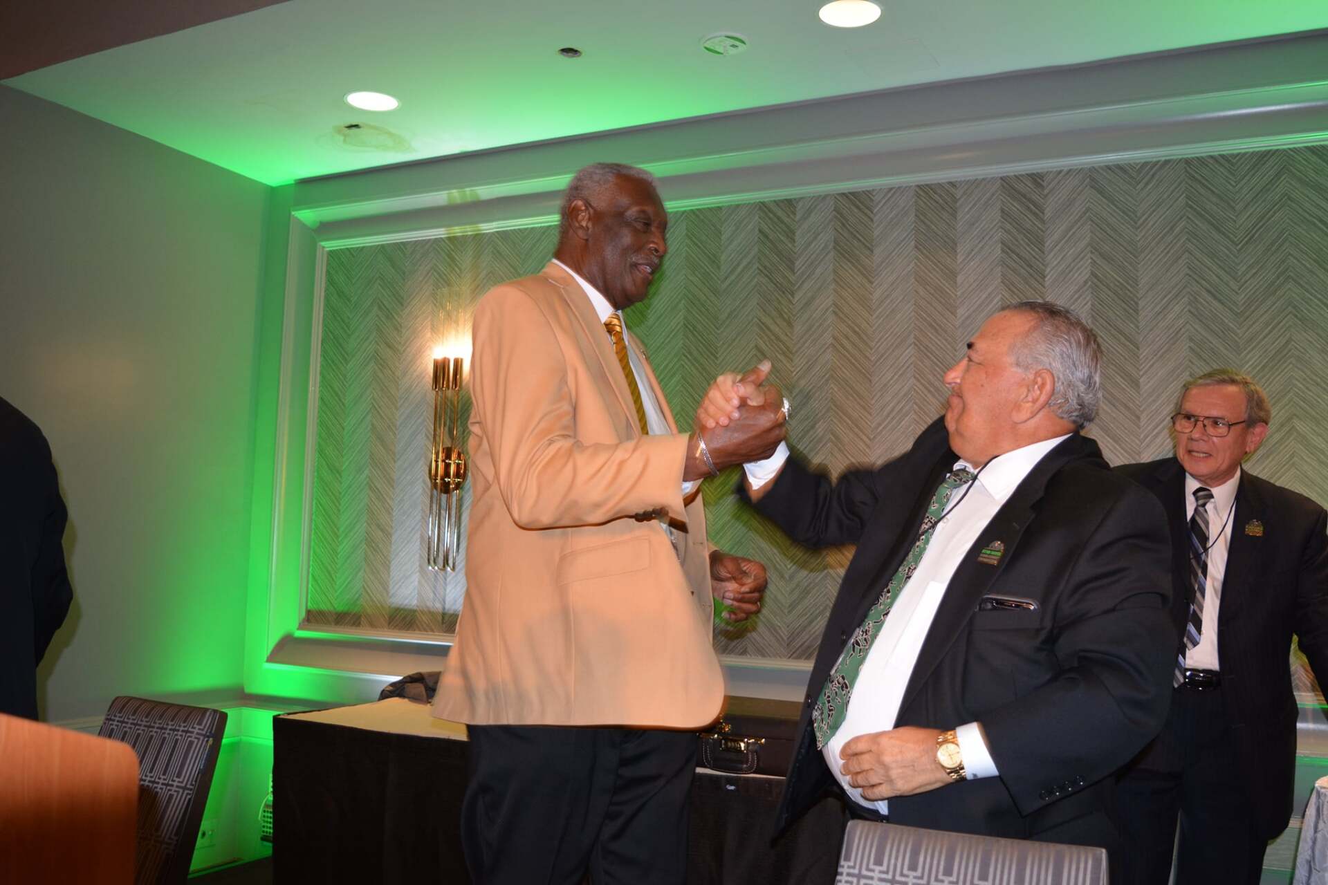 Two men in suits are standing next to each other in a room.