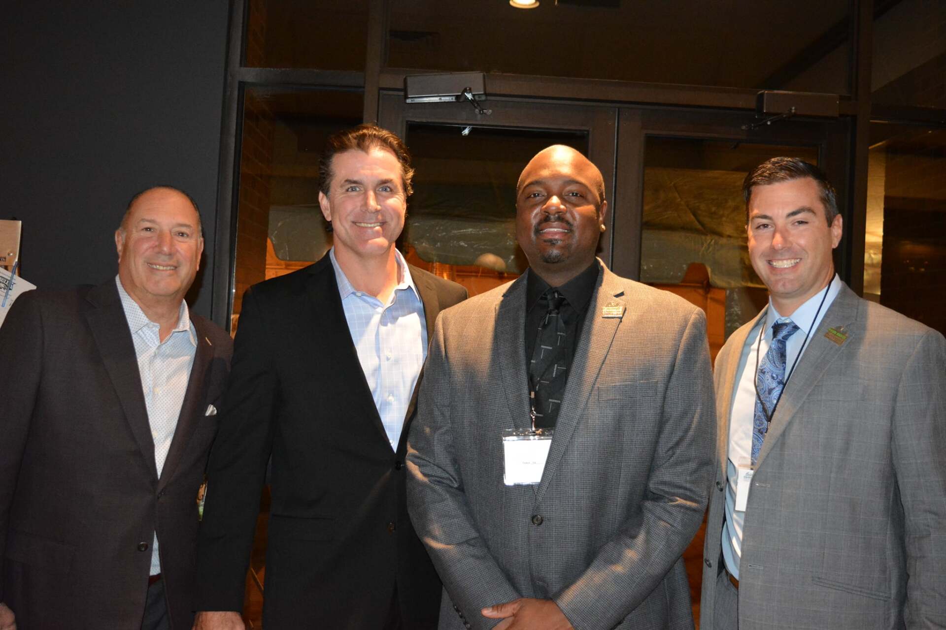 A group of men in suits and ties are posing for a picture.