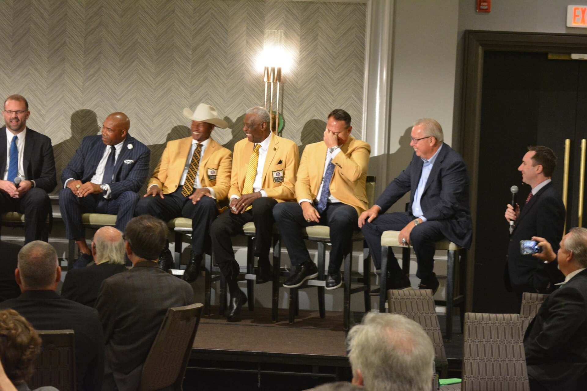 A group of men are sitting on a stage talking to each other.
