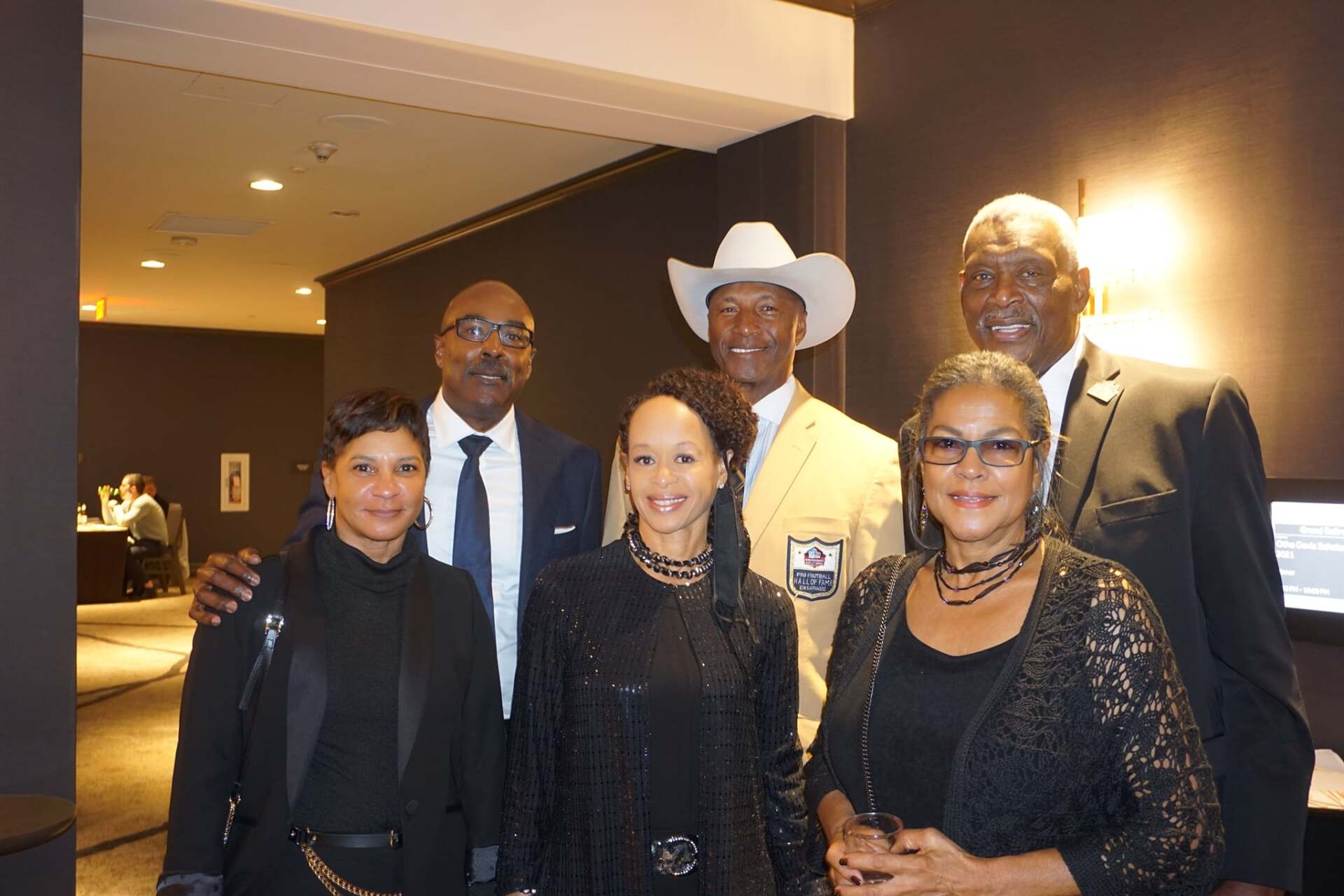 A group of people posing for a picture with one wearing a cowboy hat