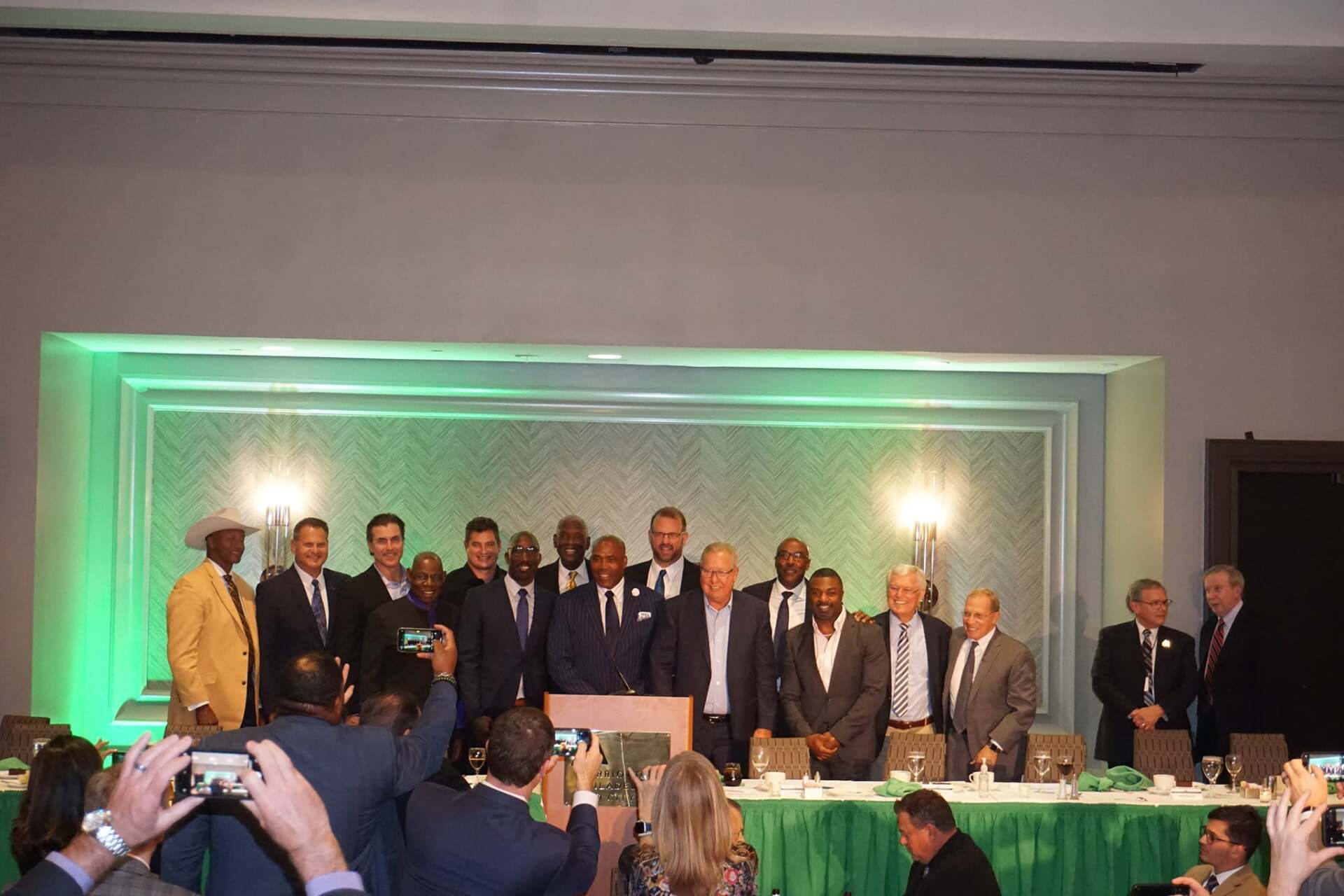 A group of men are standing in front of a podium in a room.
