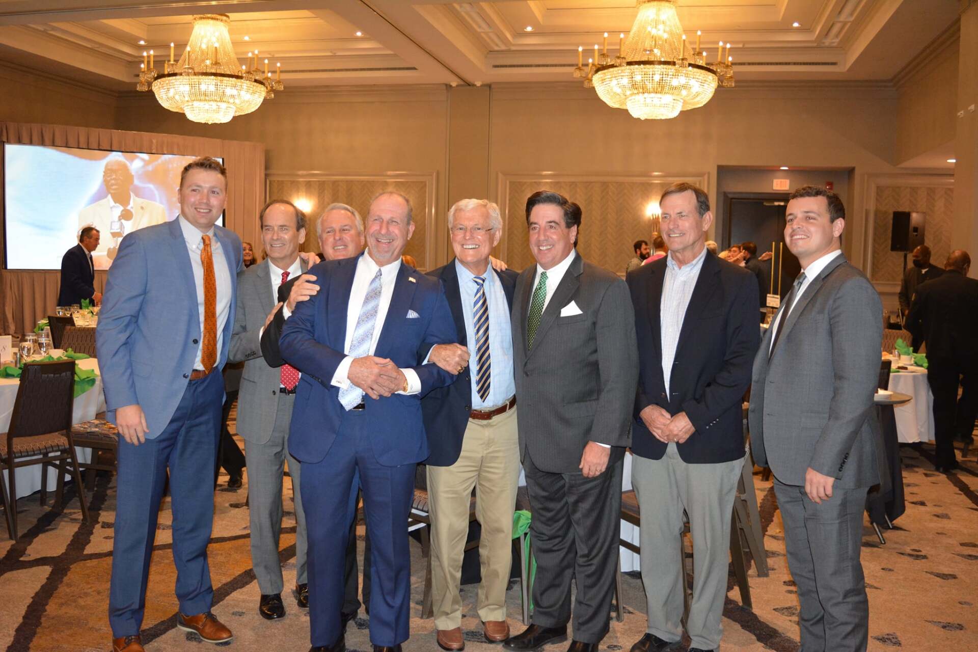 A group of men in suits are posing for a picture in a room.