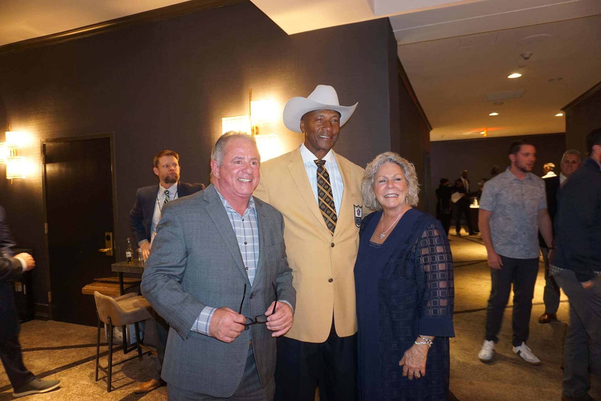 A man in a cowboy hat is posing for a picture with two other people.