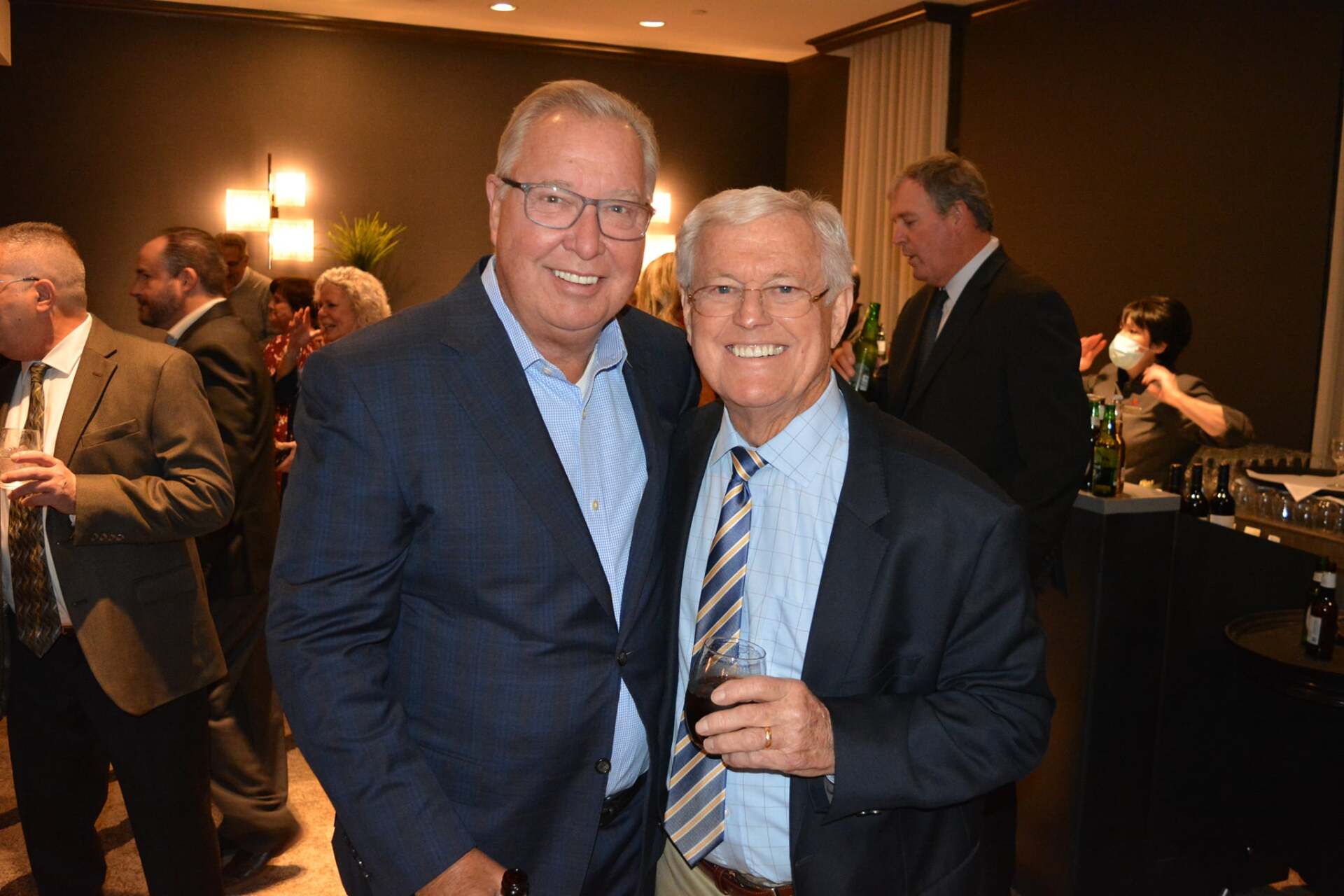 Two men in suits and ties are posing for a picture.