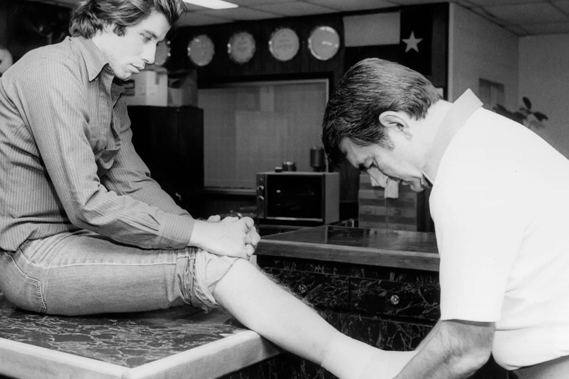 A black and white photo of two men sitting at a table