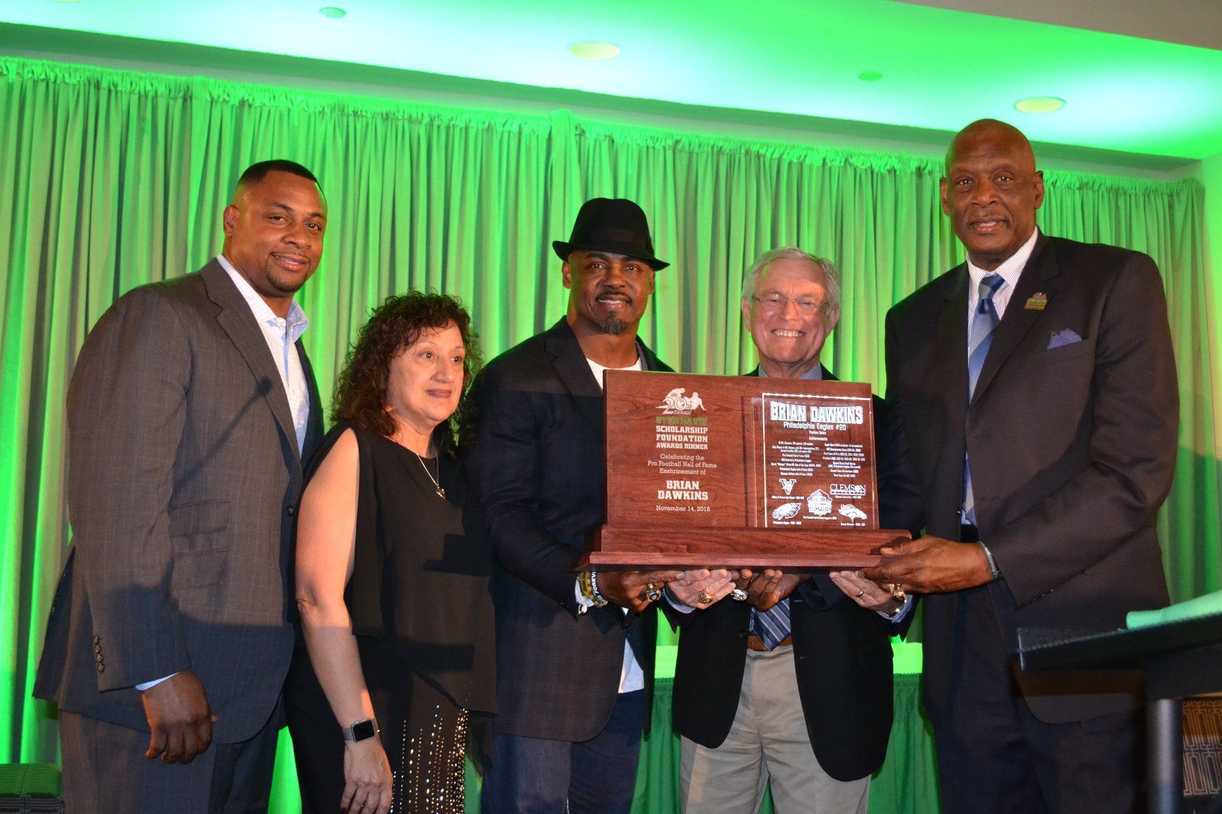A group of people are posing for a picture while holding a plaque.