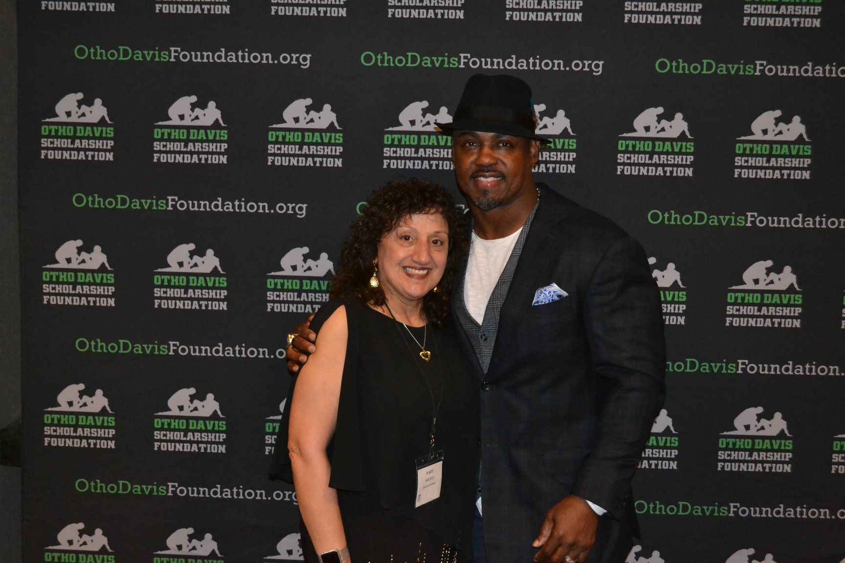 A man and a woman are posing for a picture in front of a wall that says ohio davis foundation