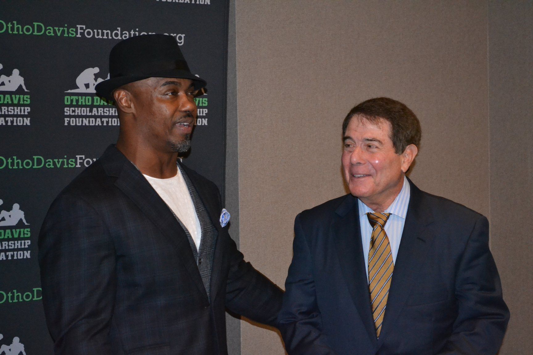Two men are shaking hands in front of a sign that says ohio davis