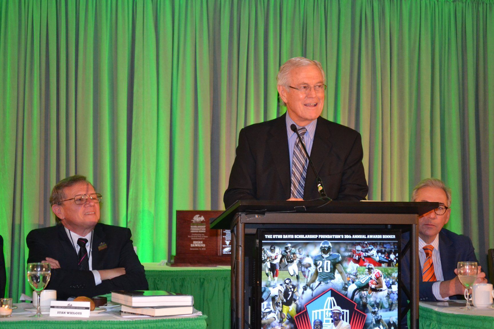 A man in a suit and tie is standing at a podium giving a speech
