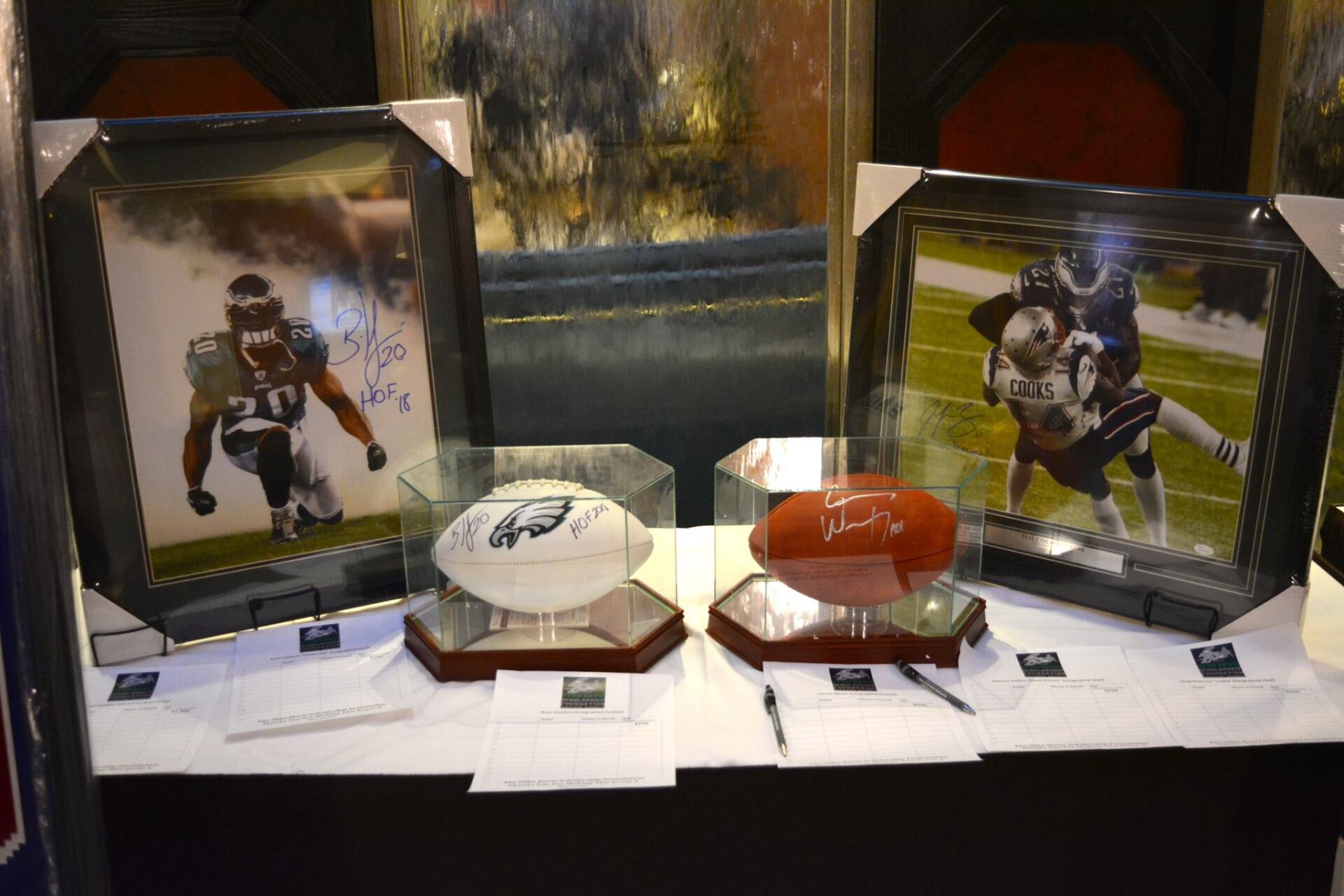 Three framed pictures of football players are displayed on a table