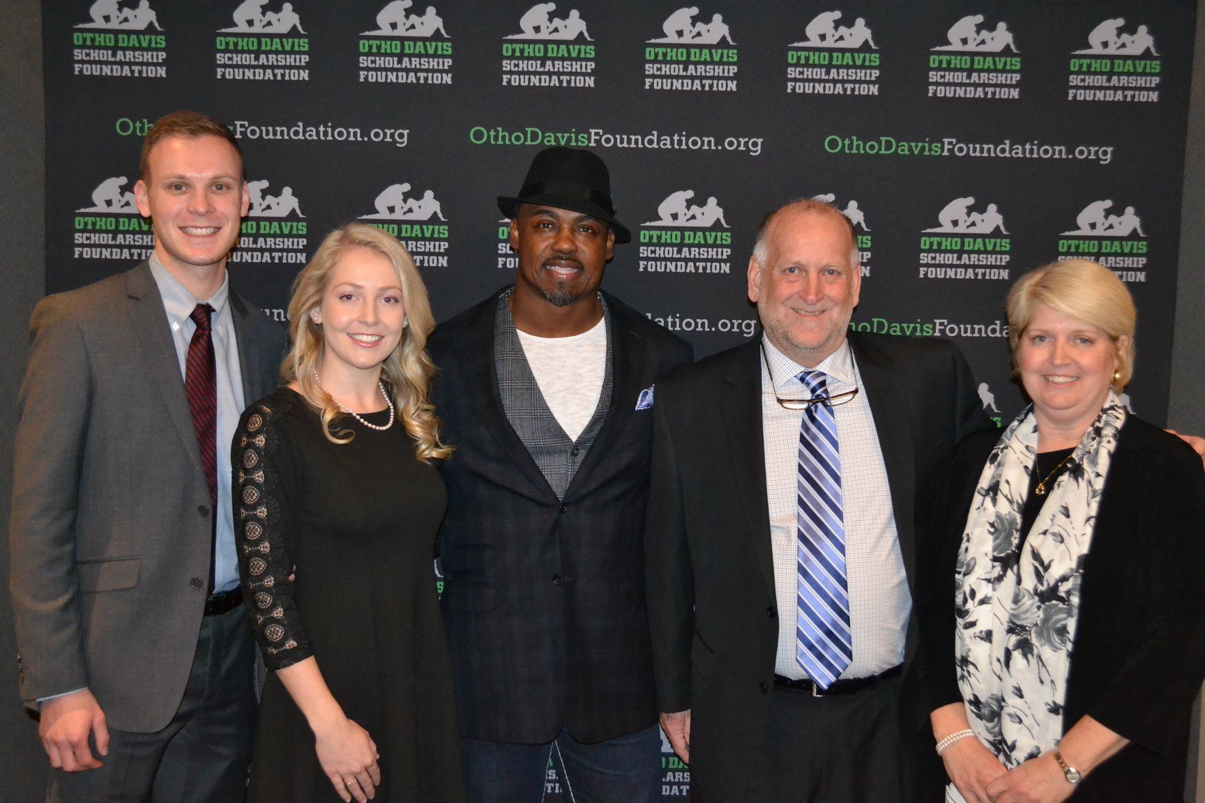 A group of people posing for a picture in front of a wall that says foundation.org