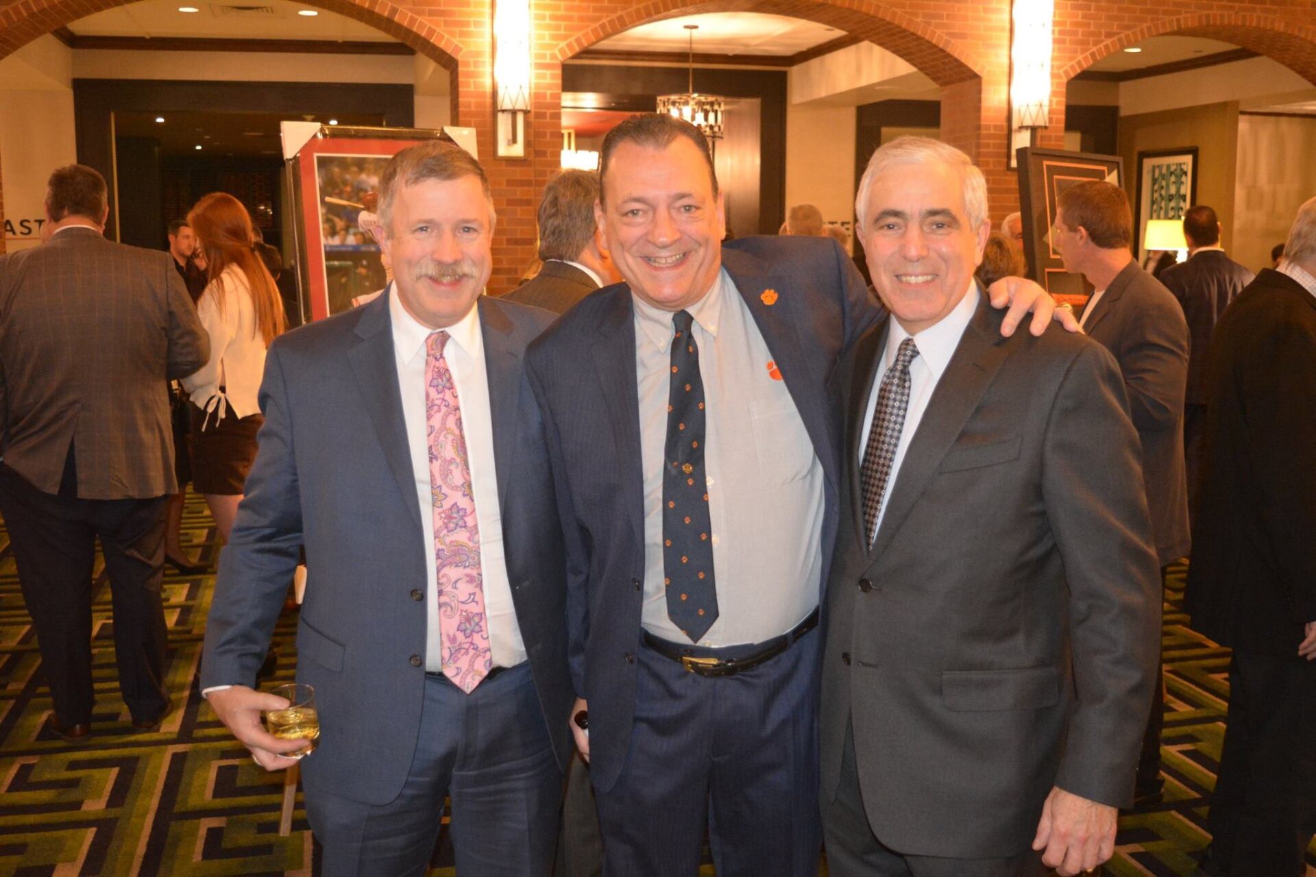 Three men in suits and ties are posing for a picture.