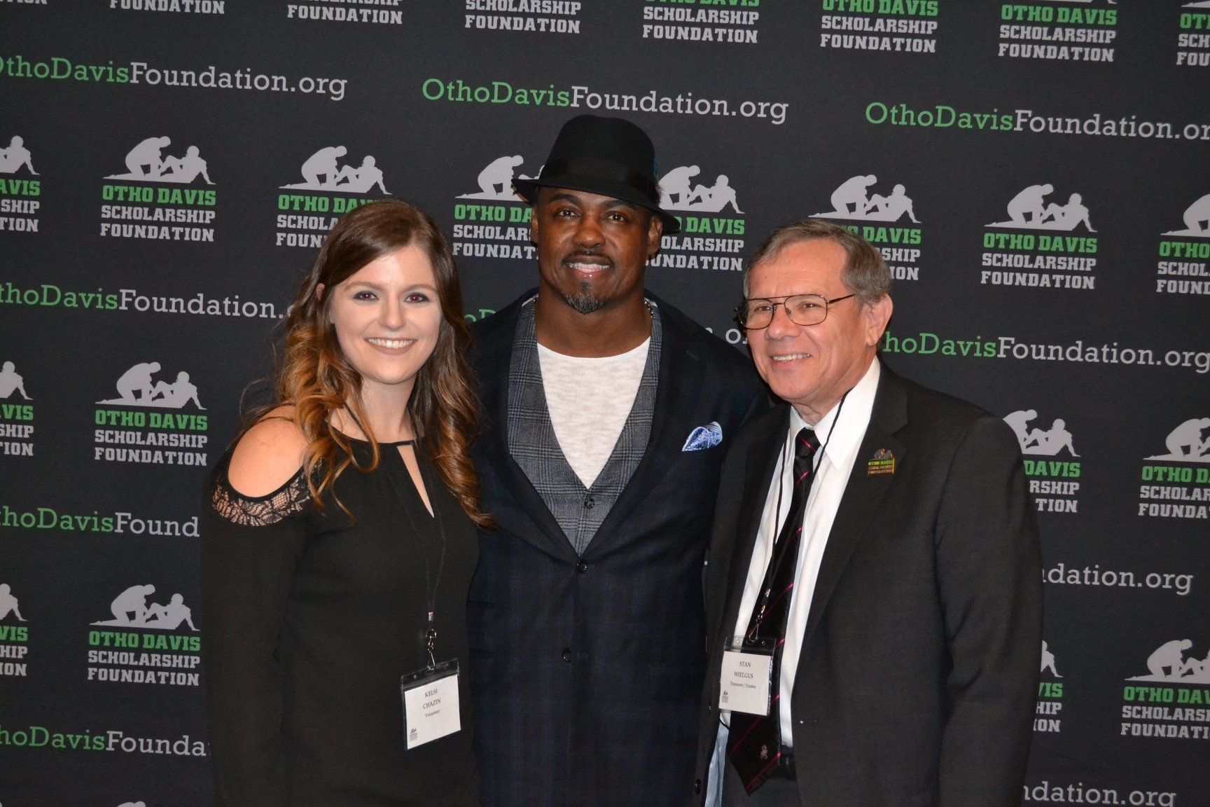 A group of people posing for a picture in front of a wall that says otto davis foundation