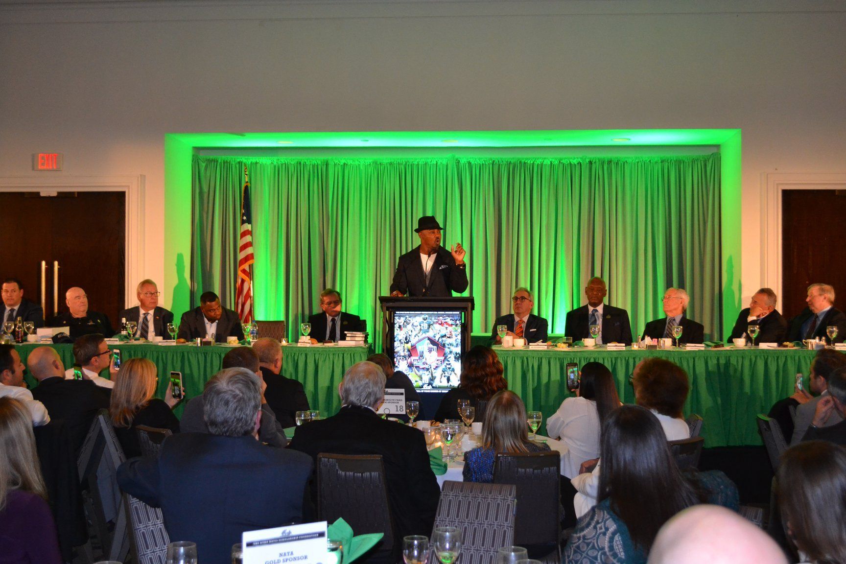A man is giving a speech in front of a group of people at a conference.